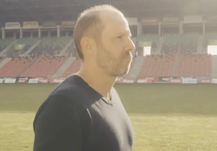 GKS Tychy trener wpatruje się w pusty stadion, gotowy na kolejne wyzwania.