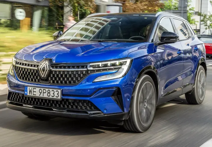 Błękitny Renault Austral pędzi po drodze, jego nowoczesny design i sportowy charakter przyciągają wzrok.