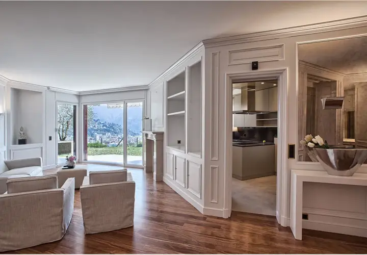Soggiorno elegante con camino, divani, vista panoramica e cucina moderna. Le pareti in cartongesso effetto legno creano un'atmosfera calda e accogliente.