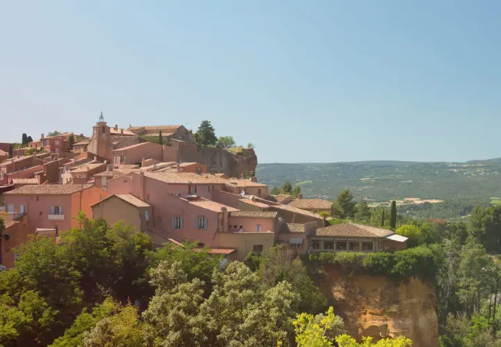 Village de Roussillon, terre du midi rosé, avec ses maisons ocres perchées sur une falaise. Un paysage provençal qui invite à la dégustation.