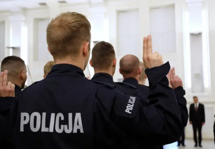 Policjanci w mundurach podnoszą ręce. Zastanawiasz się, ile zarabia pracownik cywilny w policji?