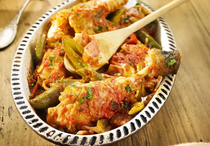 Un plat de poulet basquaise appétissant, préparé au Cookeo, garni de poivrons verts et d'une sauce tomate savoureuse.