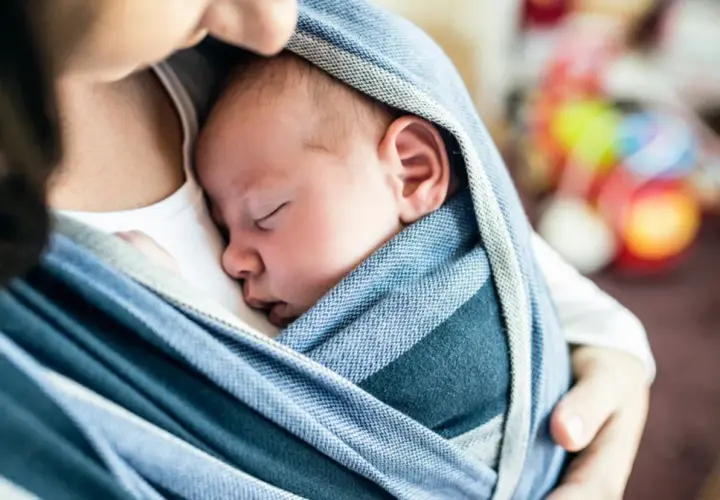 Od kiedy można nosić dziecko w chuście? Od pierwszych dni życia! Maluch śpi bezpiecznie wtulony w ramiona mamy.