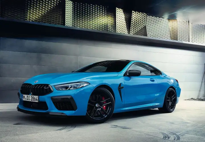 Niebieskie BMW M8 z czarnymi felgami i czerwonymi zaciskami hamulcowymi. Sprawdź aktualną bmw m8 cena.