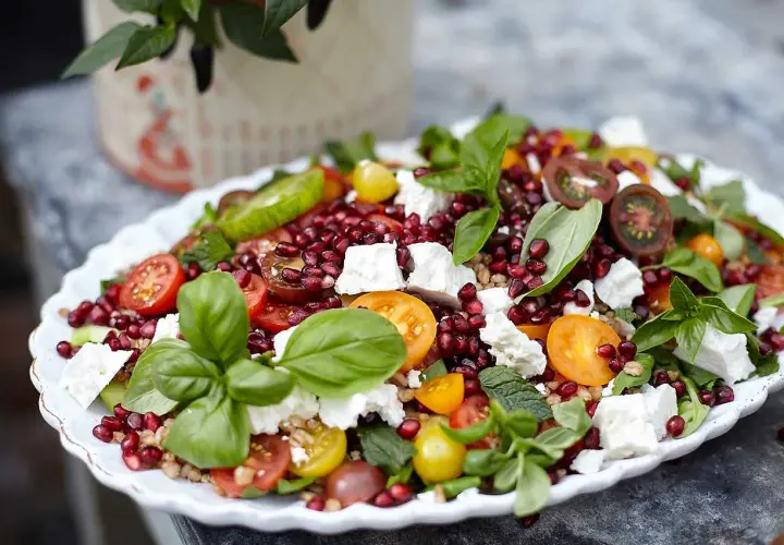 En färgstark sallad till grillat med granatäpple, fetaost, tomater och färska örter.