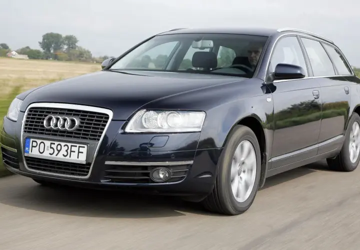 Ciemnogranatowe Audi A6 C6 2.7 TDI Avant w ruchu, z widocznym kierowcą i polskimi tablicami rejestracyjnymi.