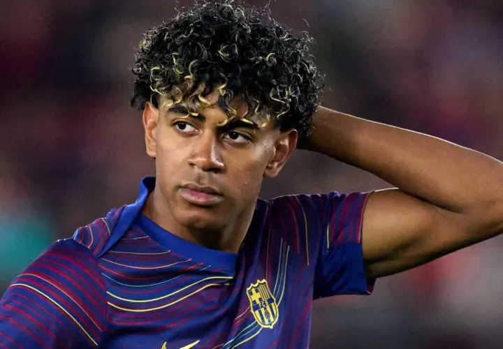 Lamine Yamal z FC Barcelony, zmartwiony po kontuzji, trzyma rękę za głową.