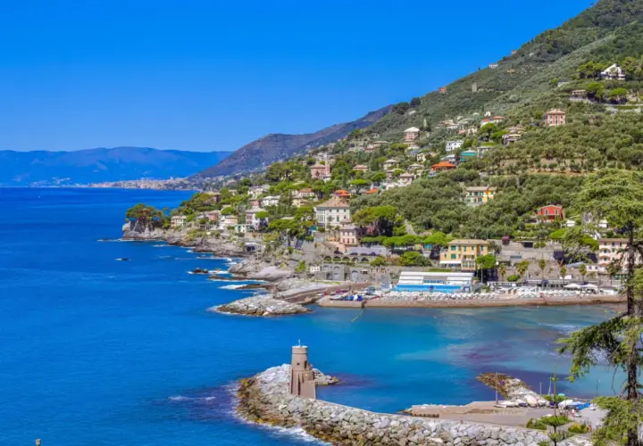 Vue pittoresque de la Riviera Italienne, avec des maisons colorées nichées sur une colline verdoyante surplombant la mer bleue.