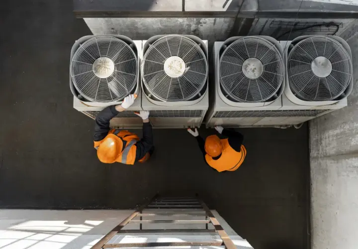 Dos técnicos revisan unidades de aerotermia que es un sistema eficiente de climatización.