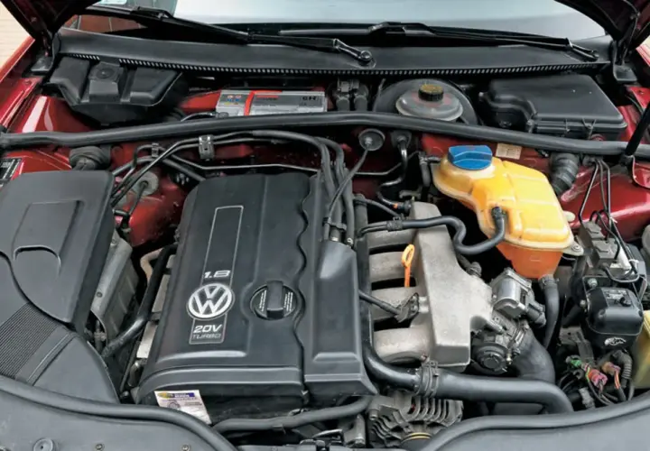 Silnik 1.8t Volkswagena z widocznym logo i oznaczeniem 20V TURBO. Widać elementy układu chłodzenia i dolot powietrza.