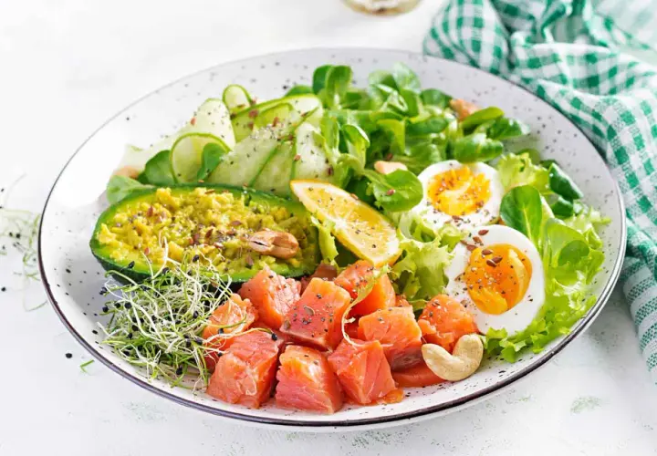 Kolorowa sałatka z łososiem, awokado, jajkiem i warzywami. Idealna na dietę low carb.