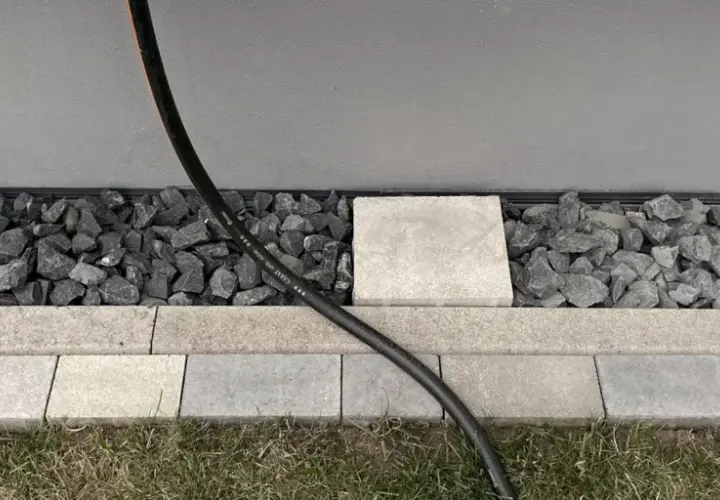 Moderner Spritzschutz am Haus: Kies und Steinplatten schützen die Fassade vor Nässe.