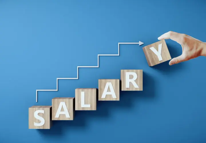 Drewniane klocki z literami tworzą napis SALARY, symbolizując drogę do jawności wynagrodzeń. Krok po kroku, ku lepszemu.