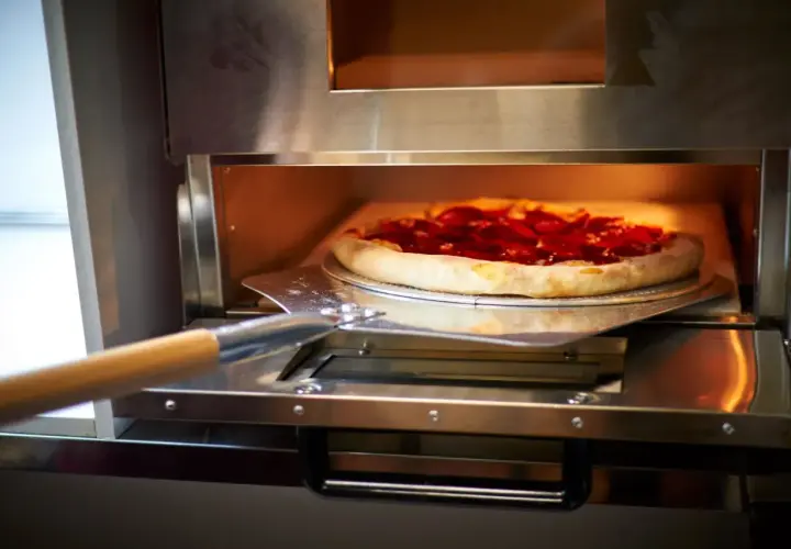 Pizza z pepperoni wjeżdża do pieca z termoobiegiem. Idealna do chrupiącego ciasta!
