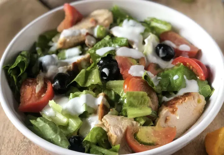 Fresca insalata di pollo con verdure croccanti, pomodori succosi e olive nere, condita con una cremosa salsa.
