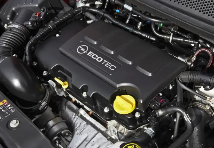 Silnik ECOTEC w Opel Astra J 1.4 Turbo. Widoczne elementy układu dolotowego i osłona silnika.