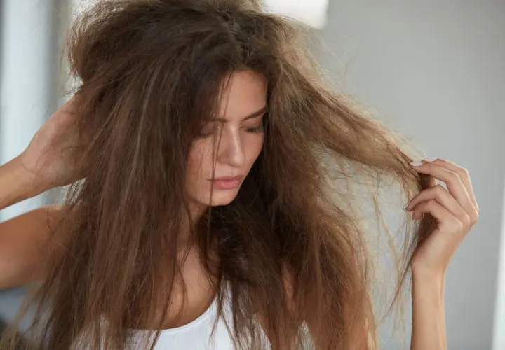 Mujer con pelo seco y sin brillo, enredado y sin vida.