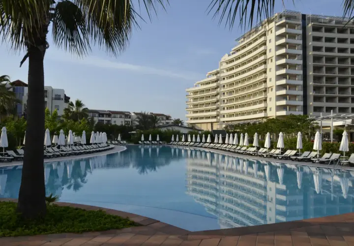 Lara, Turcja: luksusowy hotel z basenem i leżakami pod palmami.