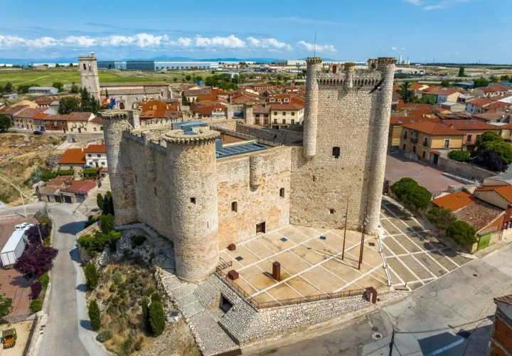 Castillo medieval en un pueblo bonito de Guadalajara, con tejados rojos y cielo azul.