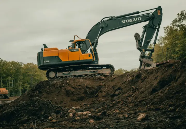 Duża koparka Volvo pracuje na budowie. Zastanawiasz się, ile zarabia operator koparki?