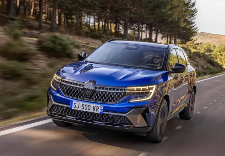 Blå Renault Austral kör på en slingrande väg genom en skog. Inga problem med denna bil, bara ren körglädje.