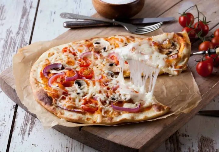 Eine köstliche Pizza mit geschmolzenem Käse, Tomaten, Zwiebeln und Pilzen. Der Teig, wie vom echten Italiener, wurde im Thermomix zubereitet.