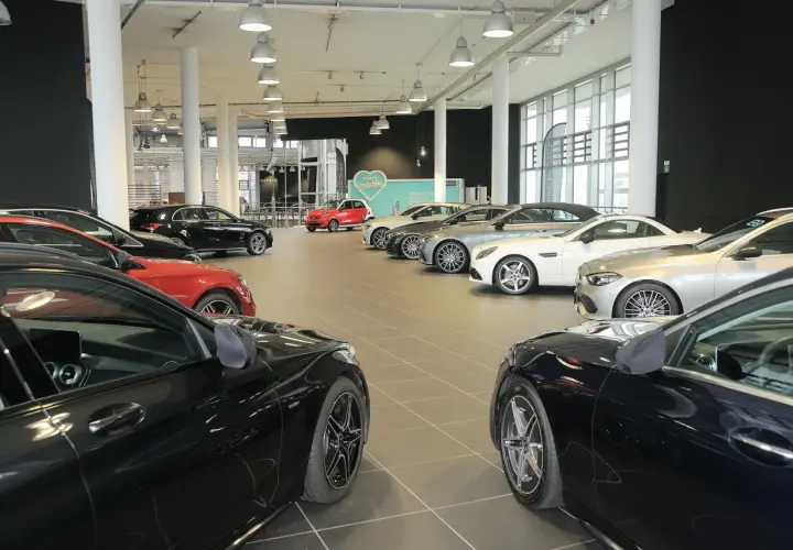Interno concessionario con diverse auto in esposizione, pronte per una permuta auto concessionario.