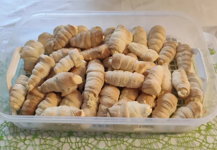 Duża porcja rurek z kremem w przezroczystym pojemniku.