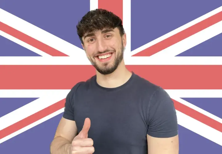 Giovane sorridente con pollice in su, sullo sfondo della Union Jack. Ha deciso di get phrasal verb per imparare l'inglese.