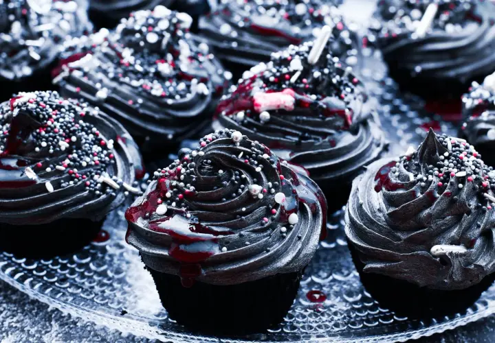Mroczne muffinki halloween z czarną polewą, czerwonym lukrem i kolorową posypką.