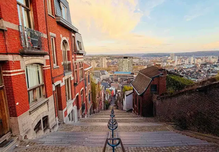 Treppen hinunter in eine Stadt in Belgien. Erkunden Sie die charmanten Gassen und genießen Sie die Aussicht – so kann man in Belgien machen!