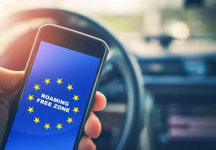 Telefon z flagą UE i napisem "ROAMING FREE ZONE". Podróżując po UE, nie trzeba włączać roamingu.