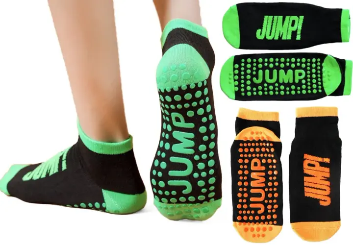 Skarpety sportowe antypoślizgowe z napisem "JUMP!" i zielonymi lub pomarańczowymi wypustkami dla lepszej przyczepności.