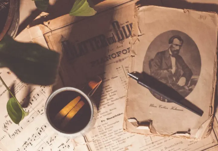 Sepia fotografia. Stare nuty, filiżanka kawy z pomarańczą i pióro.