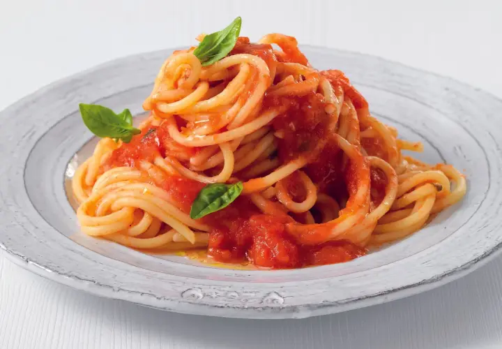 Un piatto di pasta con pomodorini freschi e basilico, un classico della cucina italiana.
