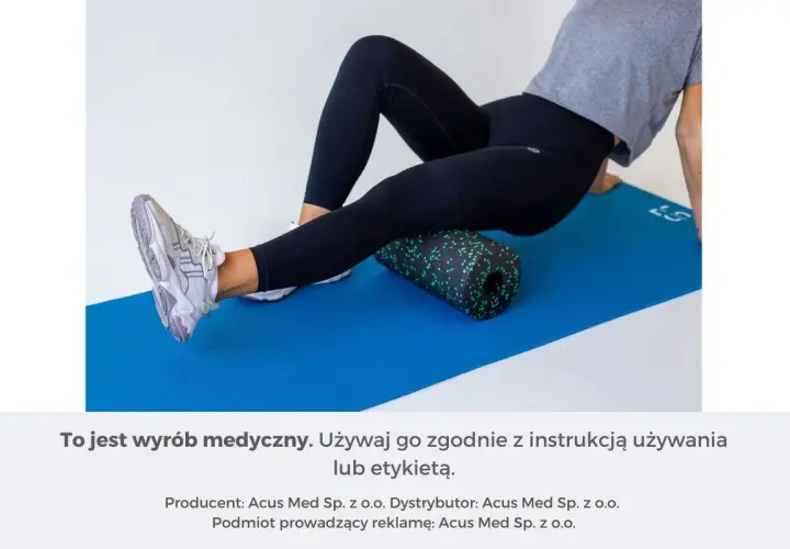 Kobieta wykonuje rolowanie przywodzicieli na macie z użyciem czarnego rollera z zielonymi kropkami.