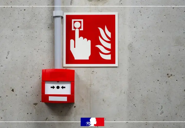 Déclencheur rouge et panneau d'alarme incendie sur mur de béton. En cas de danger, le bruit d'alarme incendie retentira.