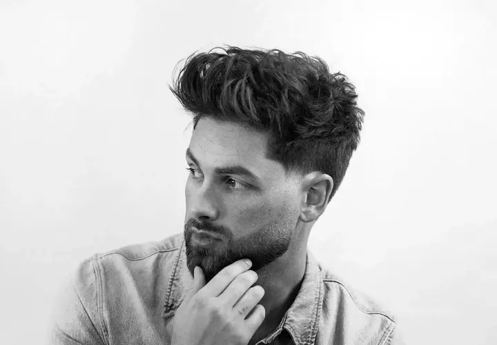Dos cortes de pelo masculinos: un taper fade con diseño y un fade más pronunciado.