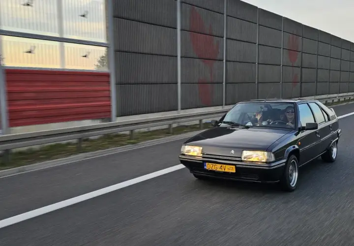 Czarny Citroën BX z zabytkowymi tablicami rejestracyjnymi jedzie autostradą.