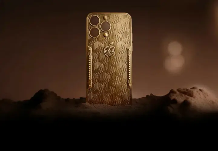 Złoty telefon z wytłoczonym wzorem, przypominający największy telefon na świecie, stoi na tle marsjańskiego krajobrazu.