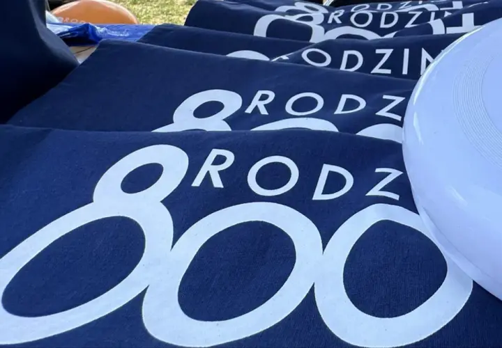 Granatowe koszulki z napisem "RODZINA 800 plus" i biały frisbee z logo 800 plus.