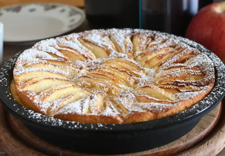 Torta di mele in friggitrice ad aria, dorata e cosparsa di zucchero a velo, pronta per essere gustata.