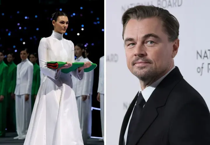 Leonardo DiCaprio na gali National Board of Review, obok modelki w białej sukni i grupy osób w zielonych strojach.