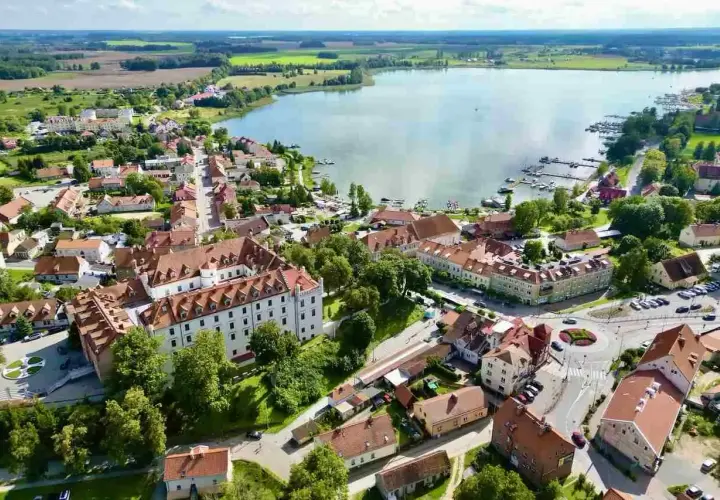 Widok z lotu ptaka na miasteczko nad jeziorem, z zamkiem i mariną. Nietypowe atrakcje Mazur czekają!