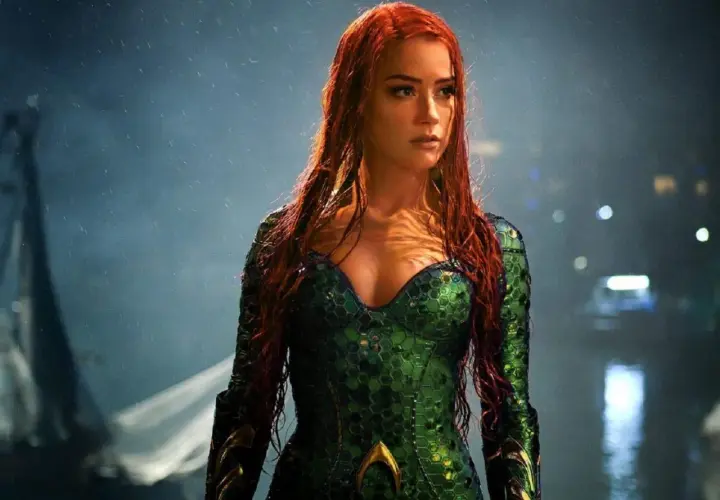 Amber Heard w zielonym kostiumie z filmu "Aquaman". Jej długie, rude włosy opadają na ramiona.