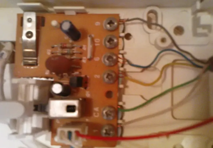 Wnętrze unifonu z widoczną płytką drukowaną, elementami elektronicznymi i przewodami.