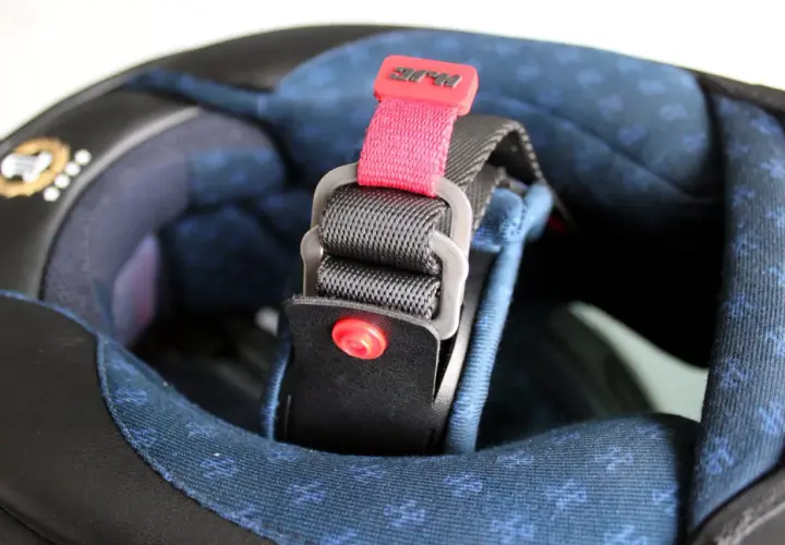 Detalle de los tipos de cierre de casco de moto: correa con hebilla de liberación rápida y logo HJC.