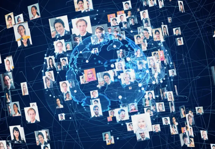 Un globo terráqueo digital rodeado de retratos de personas de diversas etnias y edades.