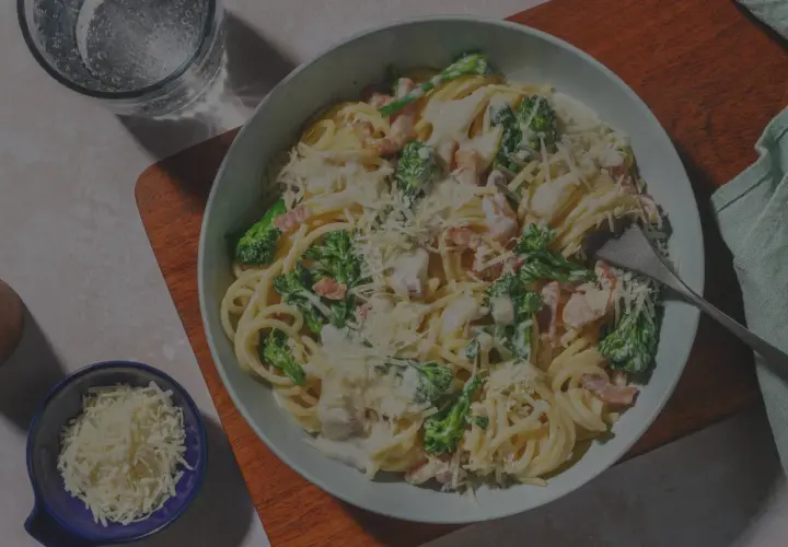 Ein Teller Spaghetti Carbonara, original italienisch, mit Brokkoli und Speck, bestreut mit Parmesan.