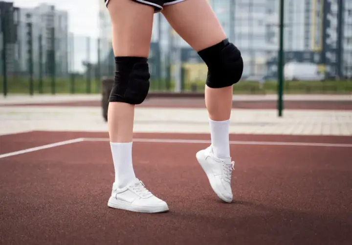 Gotowe do gry! Białe skarpetki siatkarskie, ochraniacze na kolana i sportowe buty to podstawa.